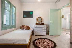 a bedroom with a bed and a mirror and a dresser at Sira Stonehouse l in Volímai