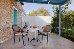 a table and two chairs on a patio at Sira Stonehouse l in Volímai +22 photos
