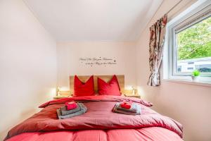 a bedroom with a large red bed with red pillows at Haus Ferdi in Koblenz
