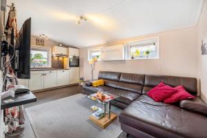 a living room with a leather couch and a kitchen at Haus Ferdi in Koblenz