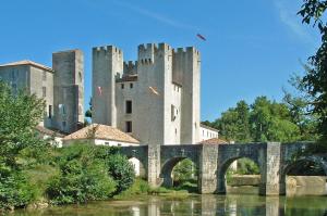 a castle with a bridge in front of a building at Maison De Campagne in Barbaste