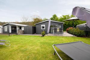 a backyard with a house with a table and an umbrella at Haus Ferdi in Koblenz