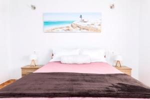 a bedroom with a large bed with a pink blanket at Villa Ralue in Tuineje +17 photos