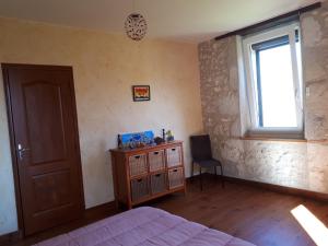 a bedroom with a bed and a window and a chair at Maison De Campagne in Barbaste