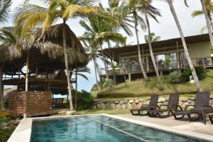 a resort with a swimming pool and palm trees at Villa 2 Altomar in Palomino
