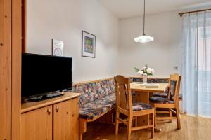 a living room with a couch and a table with a television at Appartments Reichegger in Villa Ottone