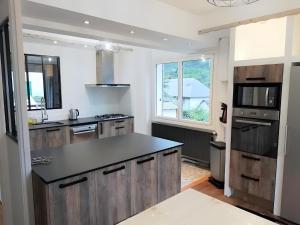 a kitchen with wooden cabinets and a black counter top at Sublime Chalet 14 Pers Spa Extrieur in Cauterets