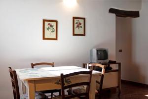 a dining room with a table and a tv at Il piccolo fienile in Vessalico