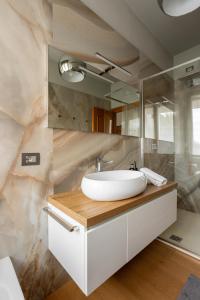 a bathroom with a sink and a marble wall at Suite 51 - Arona in Arona +33 photos