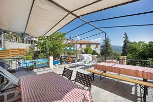 a patio with a table and benches and a pool at Il piccolo fienile in Vessalico