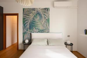 a bedroom with a white bed and a painting on the wall at Suite 51 - Arona in Arona