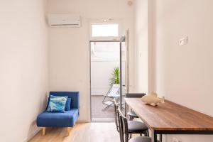 a dining room with a wooden table and a blue chair at Micenei Homes in Otranto