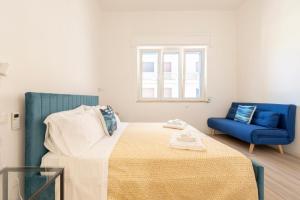 a bedroom with a bed and a blue chair at Micenei Homes in Otranto