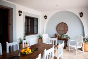 a dining room with a wooden table and white chairs at Villa Monsalva in Monte San Miguel