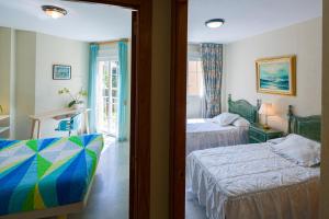 a hotel room with two beds and a window at La Reserva de Alvarito in Marbella