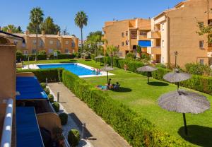 a view of a yard with umbrellas and a swimming pool at La Reserva de Alvarito in Marbella