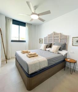 a bedroom with a bed with a ceiling fan at Flat Sun Garden in Torrox +16 photos