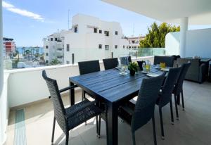 a wooden table and chairs on a balcony at Flat Sun Garden in Torrox