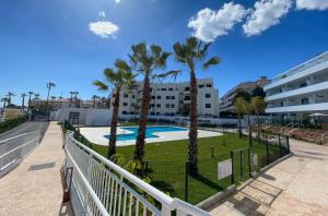 a balcony with palm trees and a swimming pool at Flat Sun Garden in Torrox