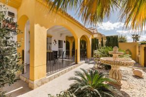 a yellow house with a courtyard with a fountain at Villa Sueño in Mazarrón