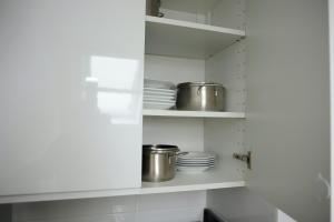 a kitchen with white shelves and pots and pans at Ferienhaus Friedrichskoog - Spitze in Friedrichskoog-Spitze