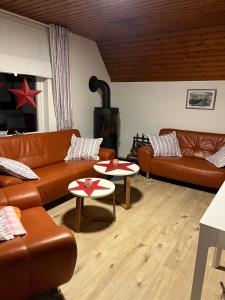 a living room with leather couches and a fireplace at Ferienhaus Friedrichskoog - Spitze in Friedrichskoog-Spitze