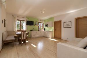 a kitchen and living room with a table and chairs at Stompferhof Familienapartment in Caldaro +4 photos
