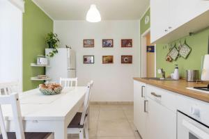 a kitchen with a table and a refrigerator at Appartamento Le Quattro Stagioni in Levico Terme