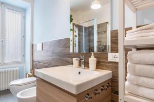 a bathroom with a sink and a toilet at Appartamento Le Quattro Stagioni in Levico Terme +24 photos
