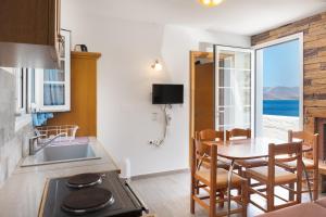 a kitchen with a table and a dining room with a view at Calliope Maille Family House in Kalymnos