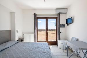 a bedroom with a bed and a table and a window at Casa Ami in Arzana