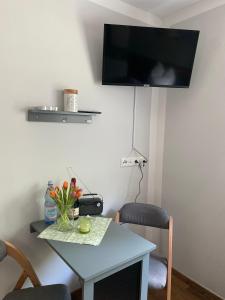 a room with a table and a tv on the wall at Zum Kölpiensee in Peenemünde
