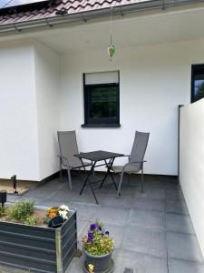 a patio with a table and chairs and flowers at Zum Kölpiensee in Peenemünde