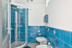 a blue tiled bathroom with a toilet and a shower at Casa Ami in Arzana +15 photos