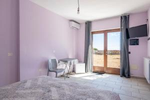 a bedroom with a bed and a desk and a window at Casa Ami in Arzana