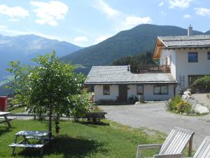 a house with a table and chairs in the grass at Grushof App Köpfl in Sluderno