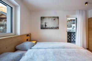 a bedroom with two beds and a window at Apartments Armeri Blue Dolomites in San Vigilio Di Marebbe