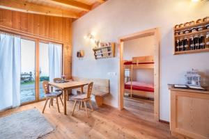 a dining room with a table and chairs and a bedroom at Grushof App Köpfl in Sluderno +15 photos