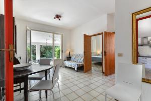 a dining room and living room with a table and chairs at Casa Camilla in Procchio