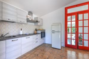 a kitchen with a white refrigerator and a red door at Casa Camilla in Procchio +16 photos
