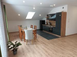 a kitchen and dining room with a table and chairs at Superior Apartment Waldblick in Westerheim