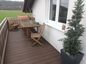 a deck with a table and chairs and a window at Superior Apartment Waldblick in Westerheim