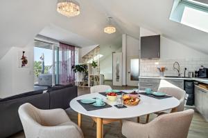 a kitchen and a living room with a table and chairs at Loft Schwenck in Kressbronn am Bodensee