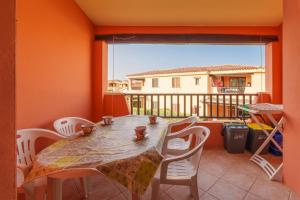 a dining room with a table and chairs and a large window at Casa Vacanze Susino in Olbia