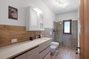 a bathroom with a sink and a toilet and a shower at Casa Loppia 2022 in Caprino Veronese +27 photos
