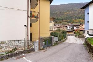 an empty street next to a yellow building at Appartamento Spormaggiore in Spormaggiore