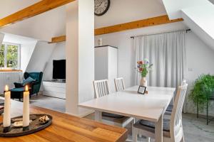 a dining room and living room with a white table and chairs at Fehrsland 2 in Dollerup