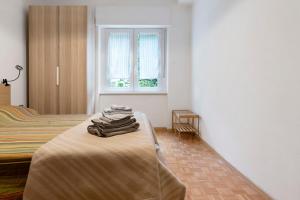 a bedroom with a bed with towels on a table at Appartamento Spormaggiore in Spormaggiore