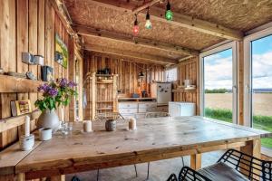 a kitchen with a large wooden table and chairs at Fehrsland 2 in Dollerup