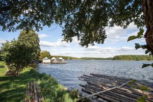 a view of a lake with a house in the distance at Ferienwohnung Bett Und Buch in Lychen